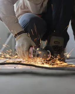 worker using electric blade to cut metal